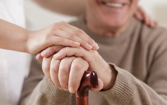 A person holding onto the handle of a cane