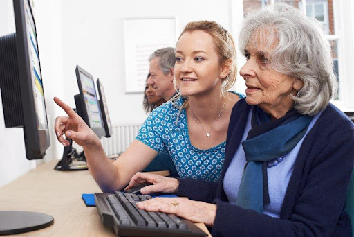 An older woman learning how to use a computer.